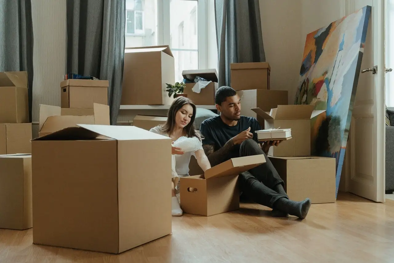 Couple unpacking moving boxes in new home, representing the emotional challenges and growth opportunities that come with major life transitions and change